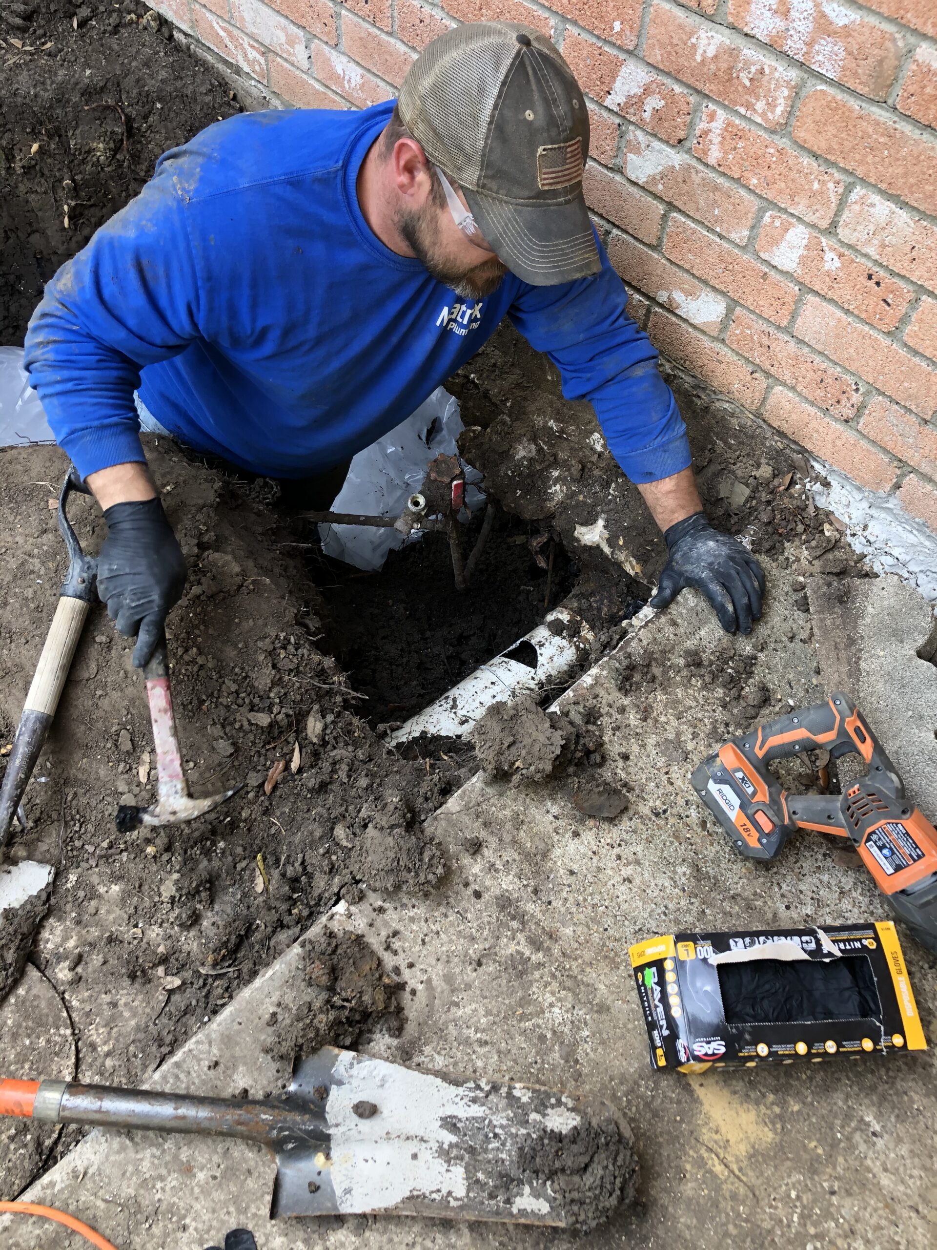 Plumber excavating a residential slab foundation to access and repair an underground plumbing leak
